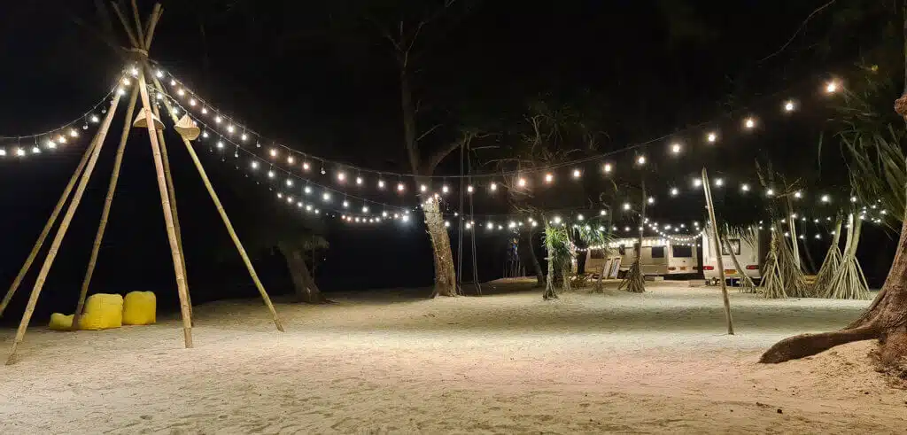 Strandcamping pyntet med lys om natten